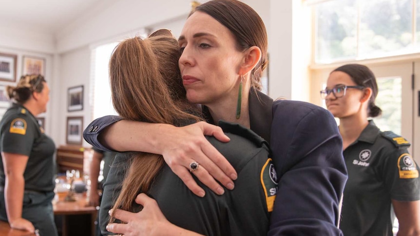 Jacinda Ardern hugging a woman wearing a search and rescue uniform.