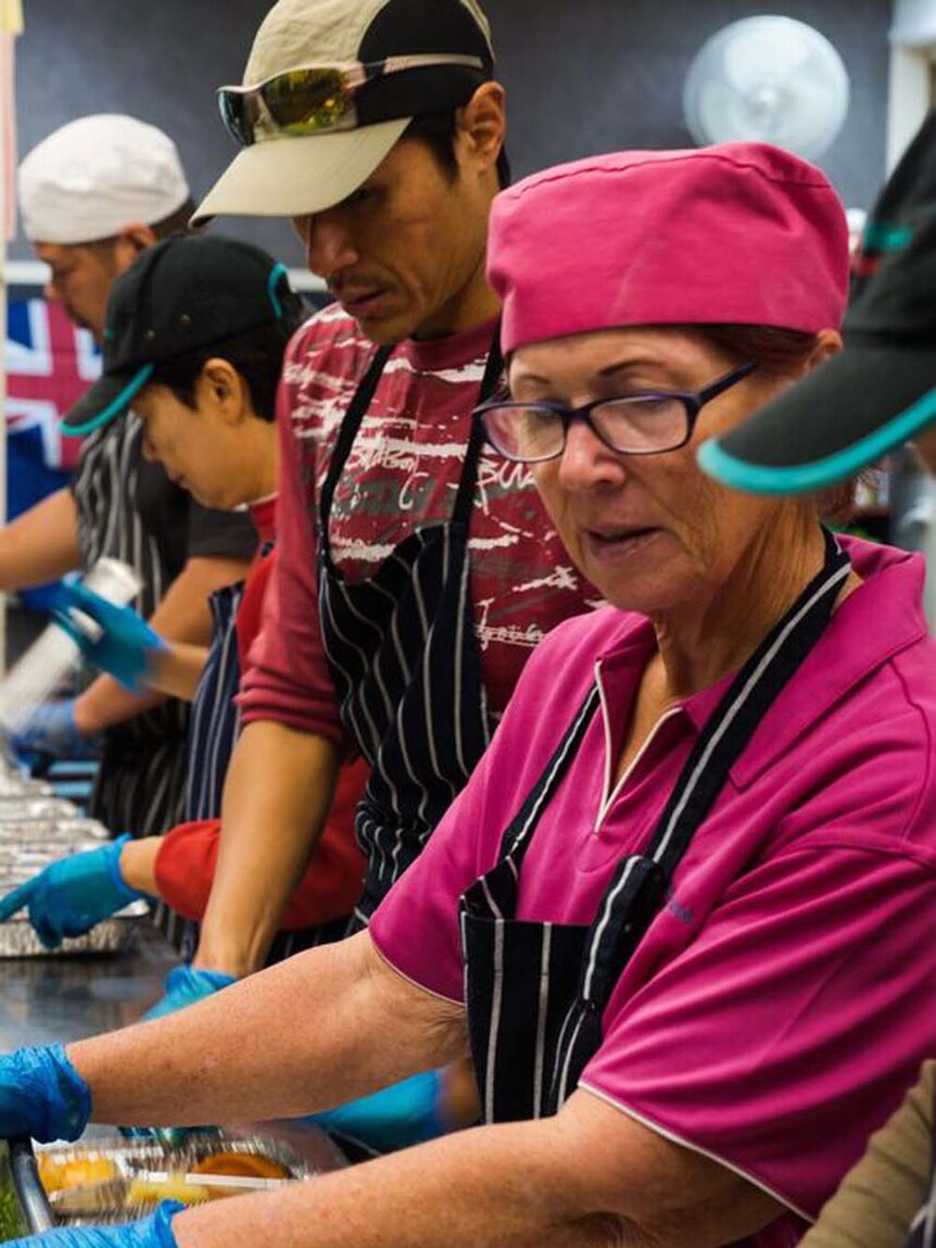 volunteers in the kitchen dishing up food