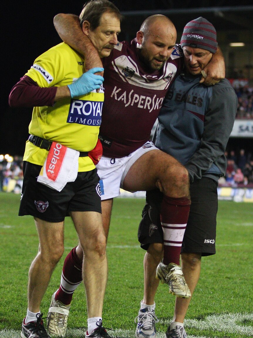 Casualties of battle ... Glenn Stewart hobbles off Brookvale Oval before half-time.