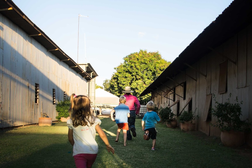 Stud manager Sally Fletcher plays tag with children at Newcastle Waters Station.