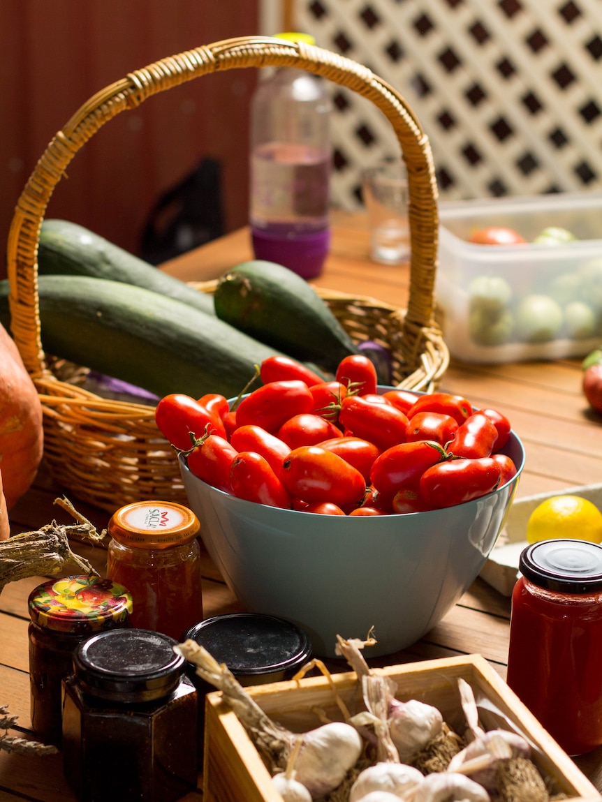 A basket of vegetables sits on a table.