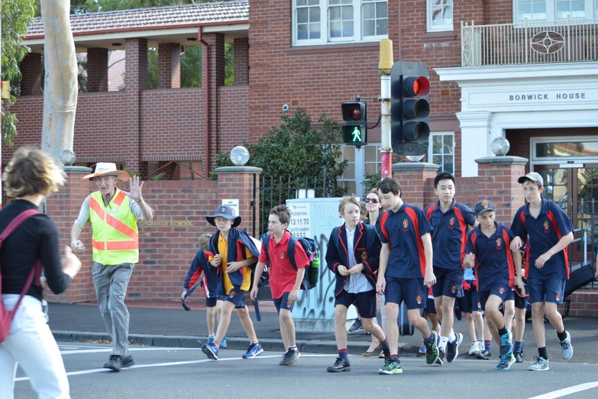 Patrick Bourke holds his hand up to stop traffic at Brighton Grammar.