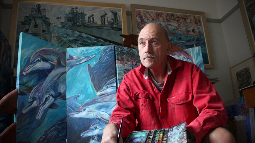 Bob McRae sits in his display room surrounded by art work.