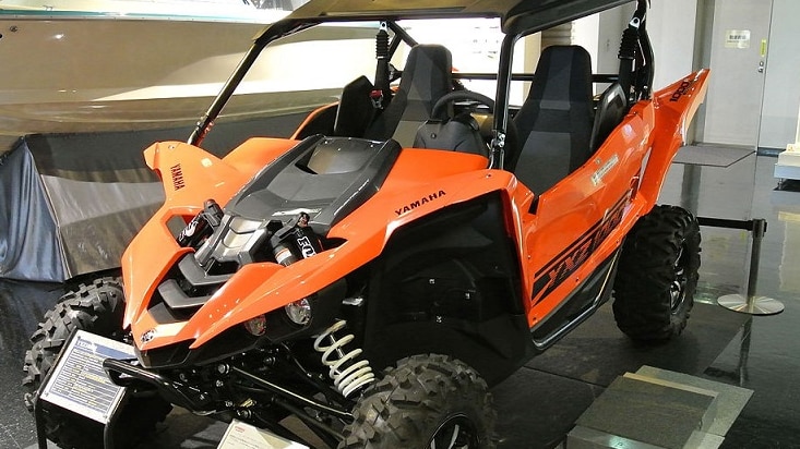 An orange and black all terrain vehicle on display