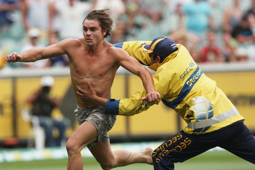 Make a dash for it ... a pitch invader evades MCG security.