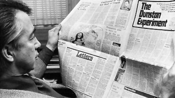 Don Dunstan reading a newspaper