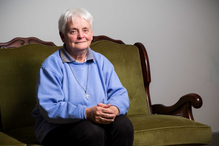 Sister Diana Santleben sits on a green lounge.