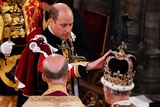 The Prince of Wales touches St Edward's Crown on King Charles III's head.