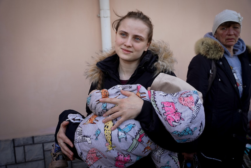 Maria Lapeikin holds her 18-month-old child 
