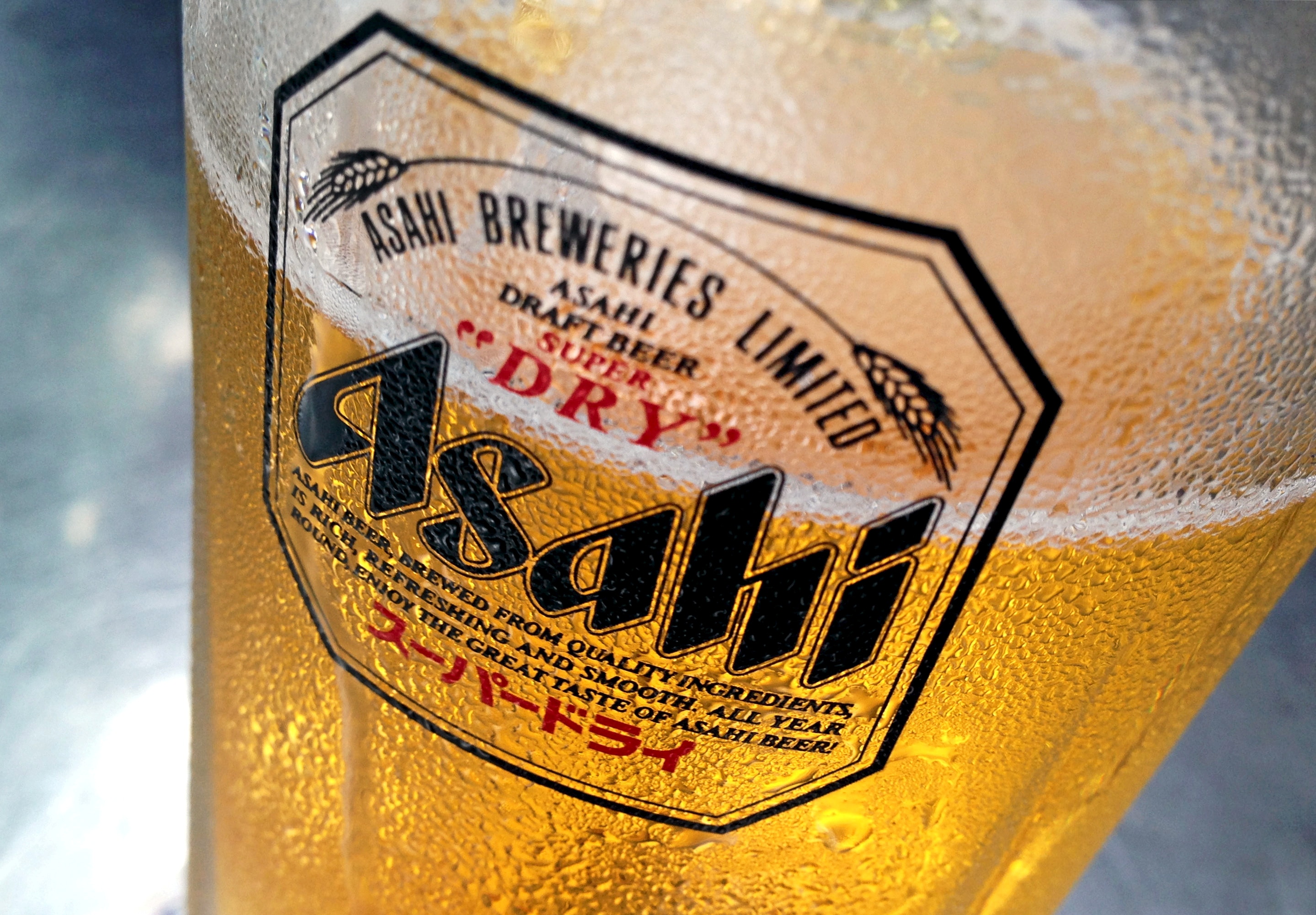 La condensación se acumula en un vaso de cerveza Asahi. 
