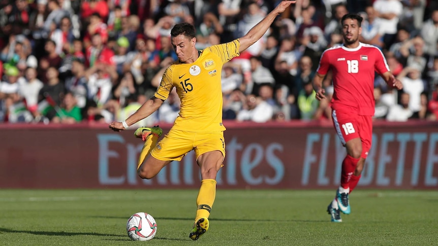 Socceroos' Chris Ikonomidis balances himself as he kicks the ball against Palestine