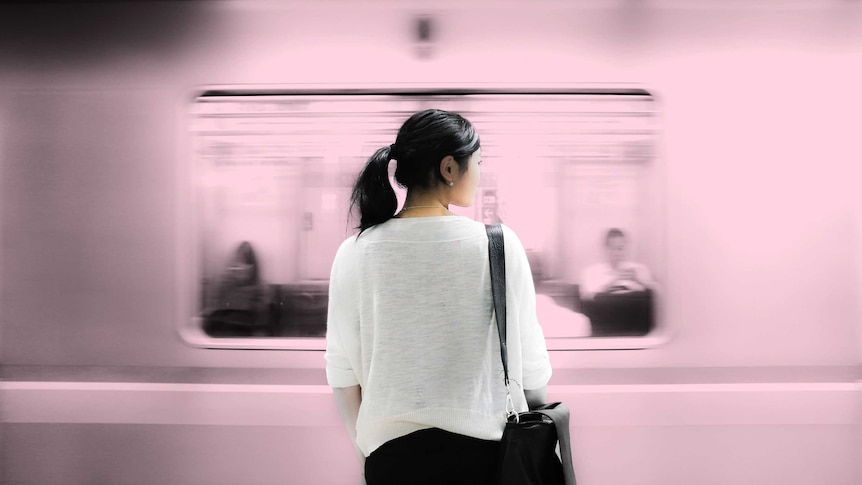 Woman waiting on the platform while a train goes past depicting the difficulty of dealing with grief at work.