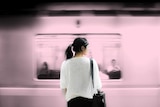 Woman waiting on the platform while a train goes past depicting the difficulty of dealing with grief at work.