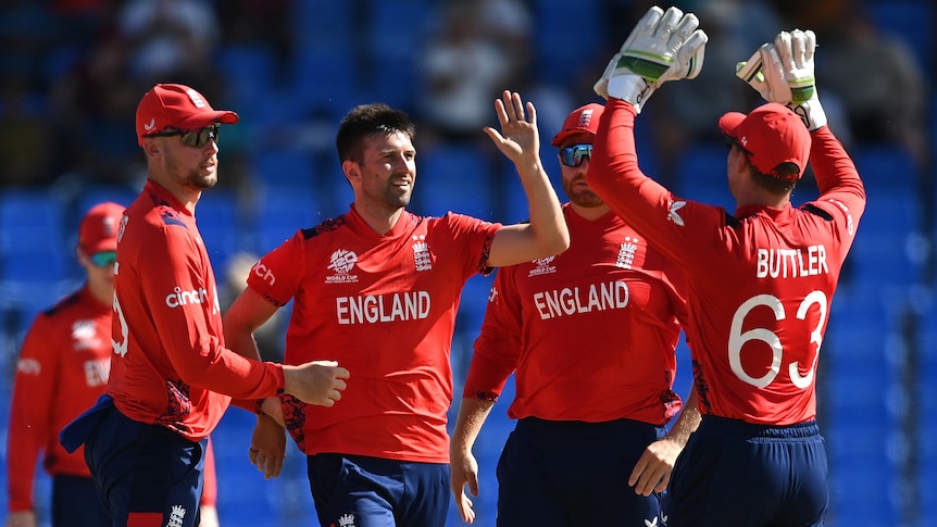 Mark Wood and three England teammates congratulate each other against Oman at the men's T20 World Cup.