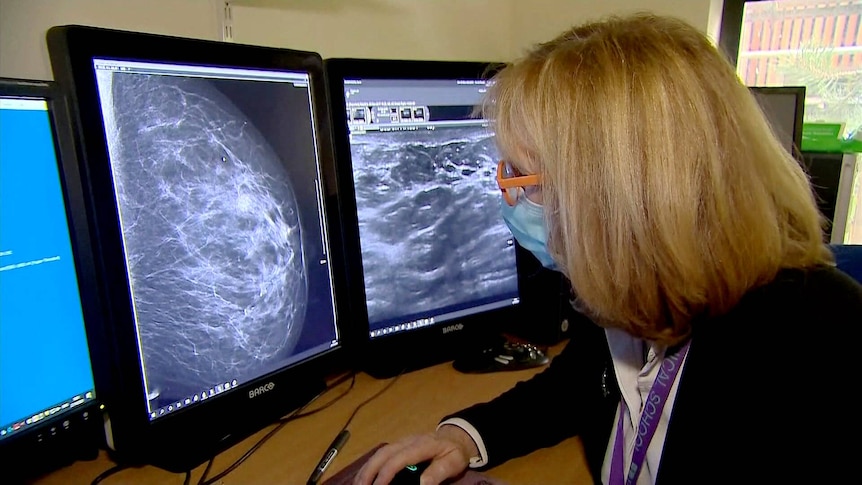 A person inspects the results of breast screening.