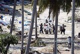 Tsunami aftermath ... rescue workers retrieve a victim in Thailand.
