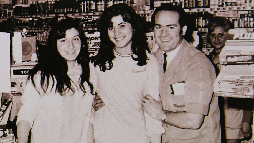 An old photo of Sam and two of his young female staff check-out staff members, including Carmel