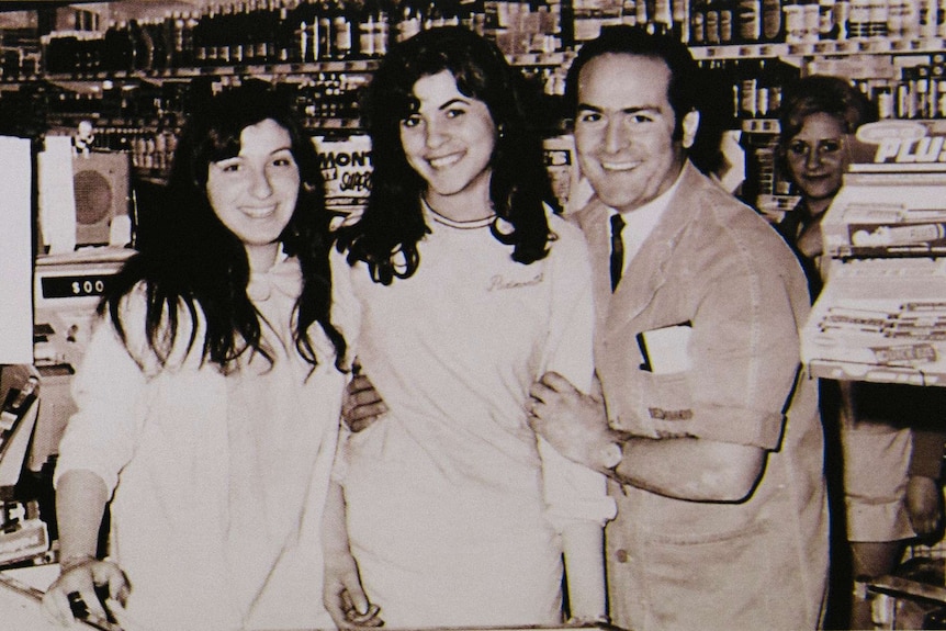 An old photo of Sam and two of his young female staff check-out staff members, including Carmel