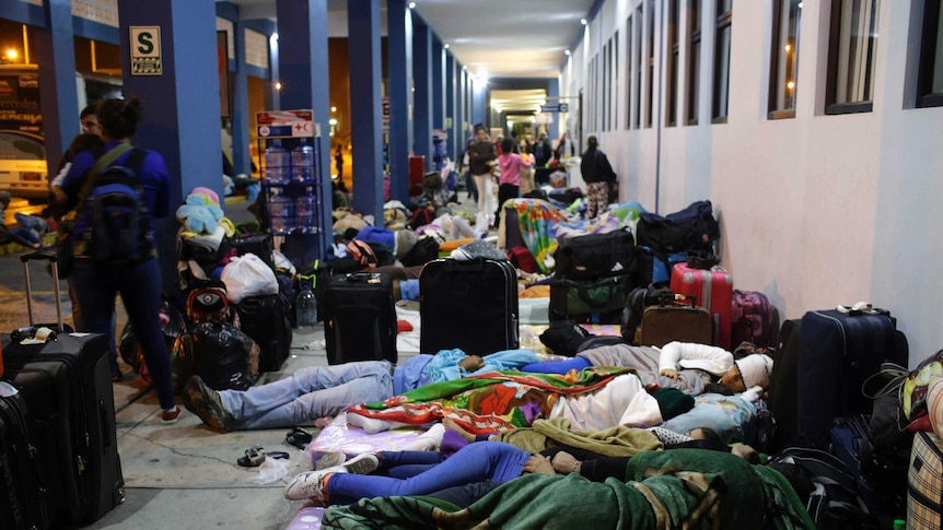 Venezuelan migrants sleep on the ground at a border crossing into Peru.