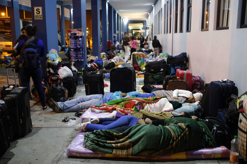 Venezuelan migrants sleep on the ground at a border crossing into Peru.