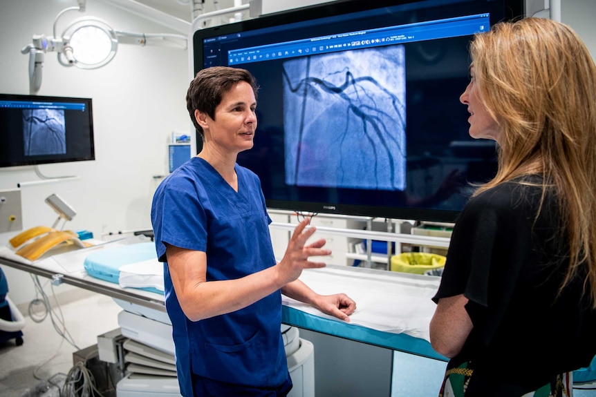 Cardiologist Professor Gemma Figtree shows Jennifer Tucker an image of the blockage in one of her arteries on a large screen.