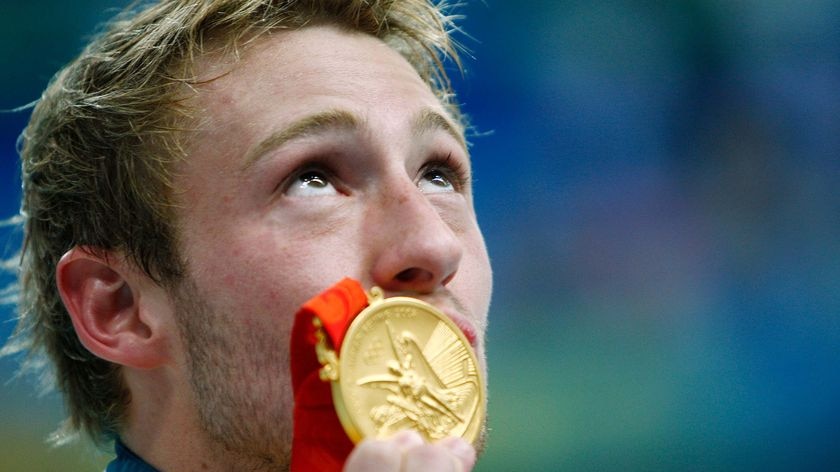 Matthew Mitcham kisses his gold medal he won in the men's 10m platform diving final