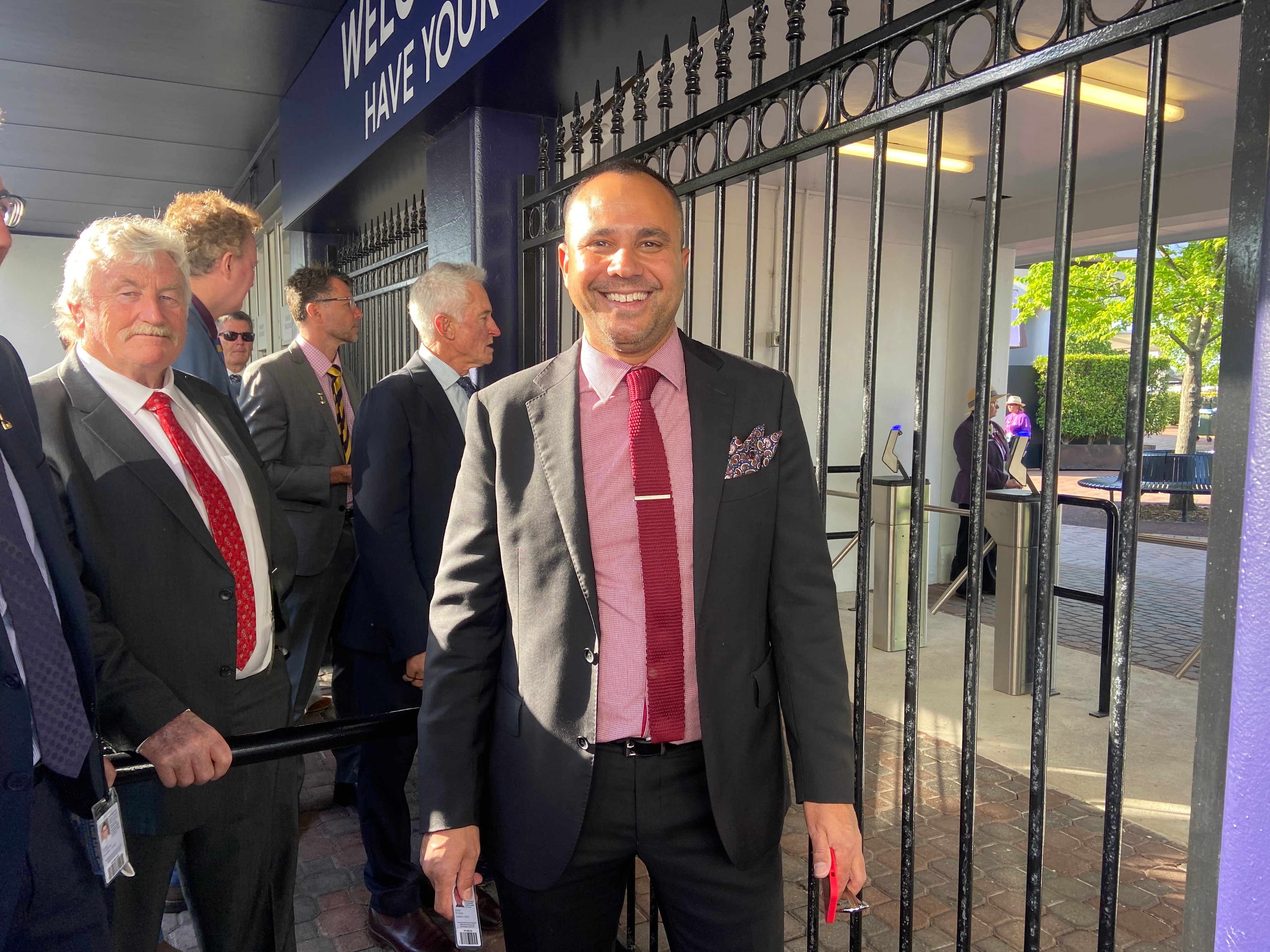 Men in suits standing before gates