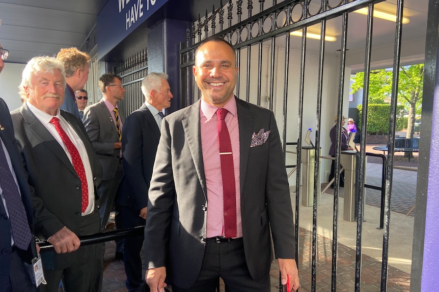 Men in suits standing before gates