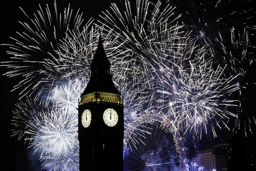 Fireworks illuminate the Elizabeth Tower, part of the Houses of Parliament, and the London Eye in central London.