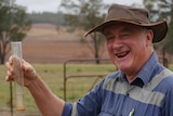 Gavin Tom holding a rain gauge.