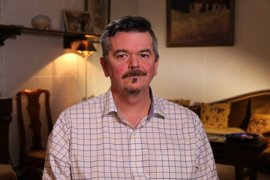 A man with a moustache wearing a shirt.