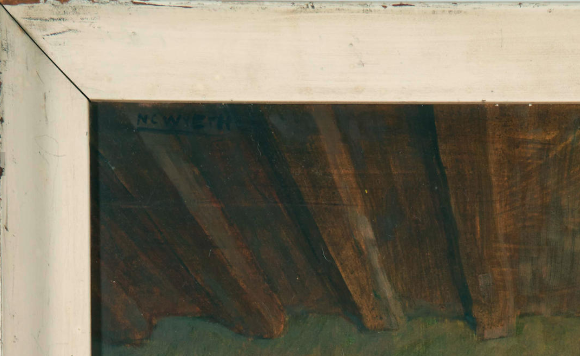A close up of the signature N C Wyeth written in black paint, disguised in the shadows of a dimly-lit rafters.