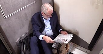 Jeremy Corbyn sits on the floor of a train.