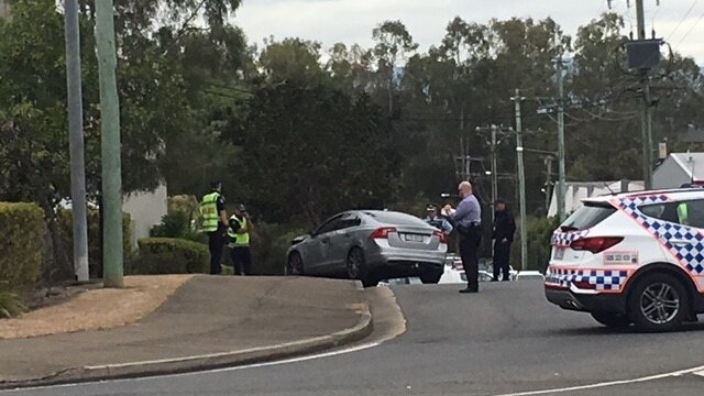 Police officers with a damaged silver car that crashed on the footpath on Vowles Street at Booval,