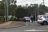 Police officers with a damaged silver car that crashed on the footpath on Vowles Street at Booval,
