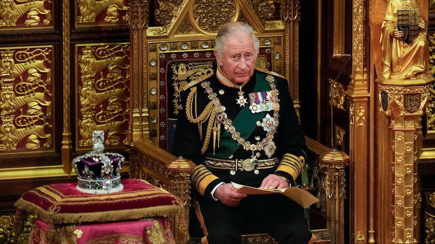 royal charles sits on golden throne next to queen elizabeth's crown