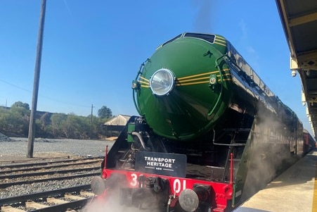 Steam train at train platform.