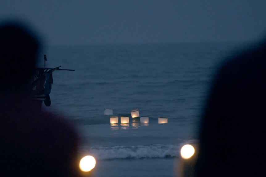 Floating lanterns are released on the water at a memorial ceremony in Taishan,