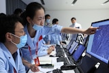 People point at computer monitors and work at the Beijing Aerospace Center.