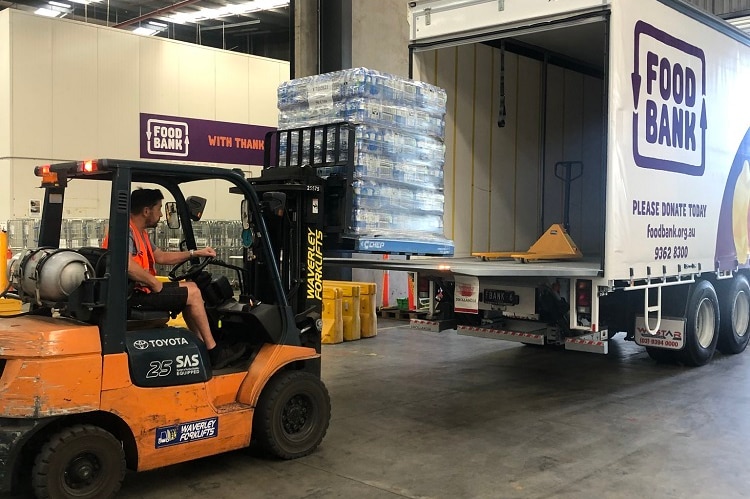 A pallet of water is lifted into a Foodbank truck.