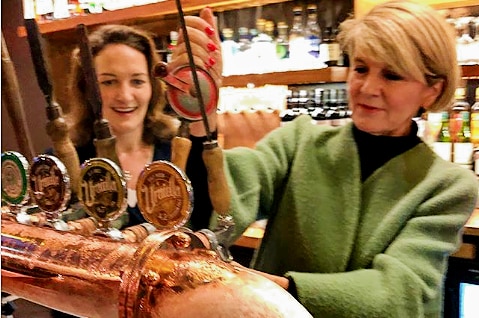 Julie Bishop behind a bar pulling a beer