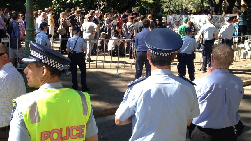Police watch over protesters from the Aboriginal tent embassy as they protest at Parliament House.