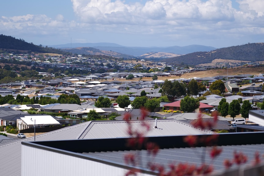 Vue de maisons s'étendant à travers une vallée peuplée.