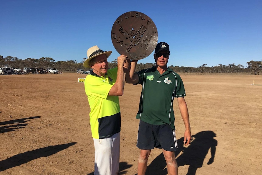 two man holding a piece of metal