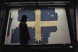 A man walks past the tattered and torn Eureka flag raised during the miner's uprising in Ballarat in 1854 mounted in a museum.