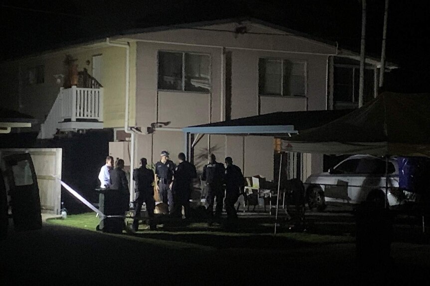 Police at a house at night after declaring the property a crime scene