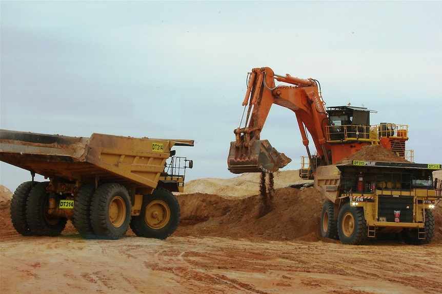 Trucks and digger in action at an Iluka mineral sands mine