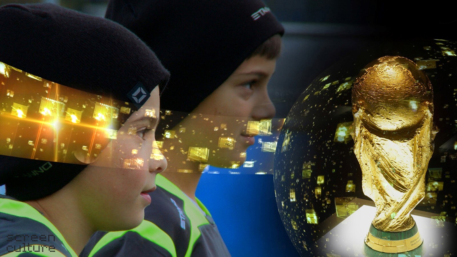 2 young boys wearing beanies and soccer jersey with statue of World Cup in right of picture