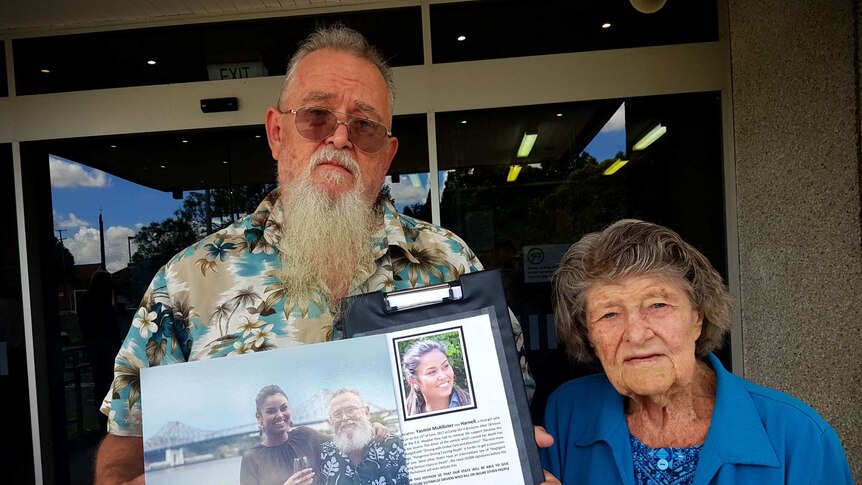 Glynn Harnell, supported by his mother, holds a picture of his daughter outside court