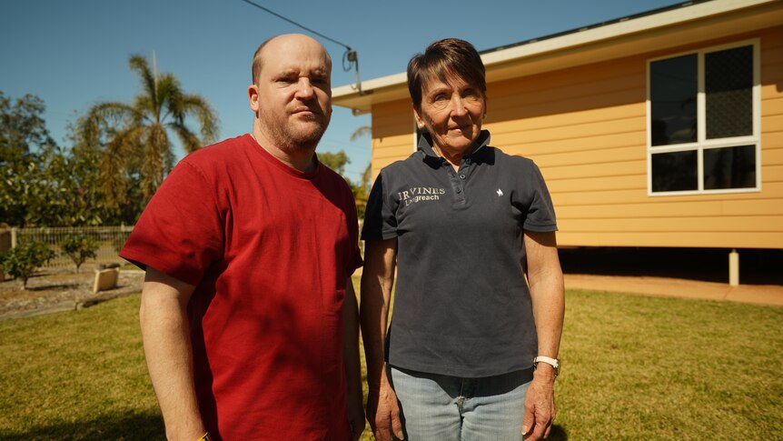 A young man and his mother stand in front of their Longreach home. 